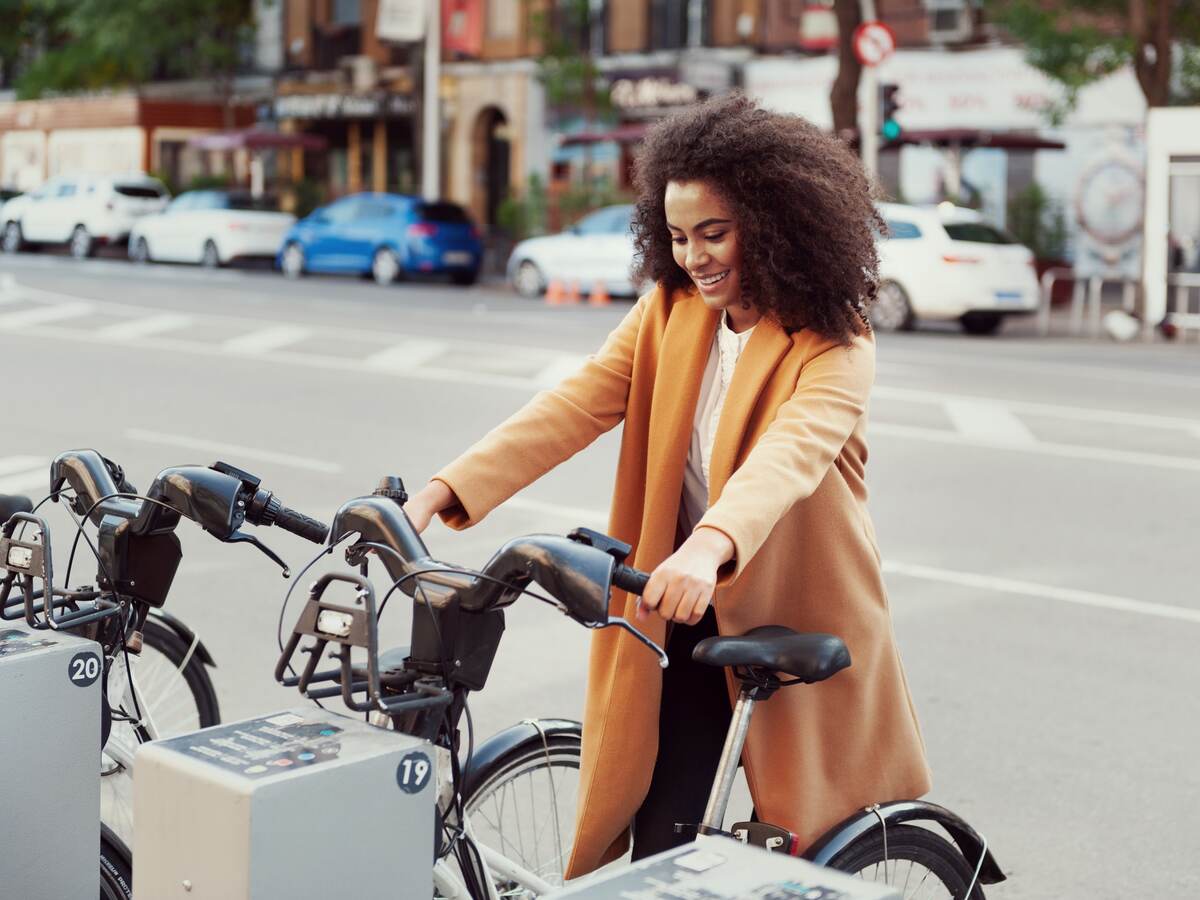 Woman in urban station with electric bicycles