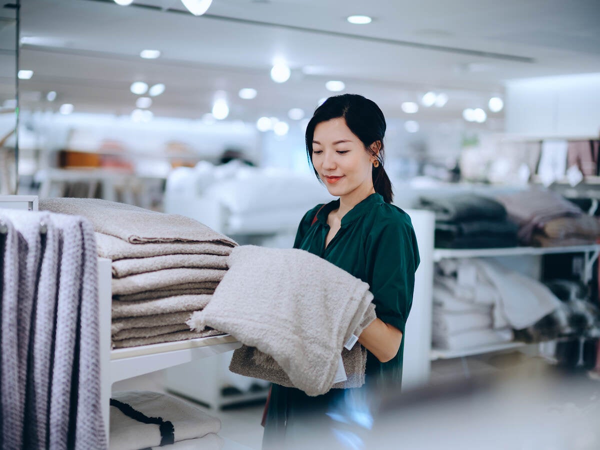 Asian woman shopping for bath towel