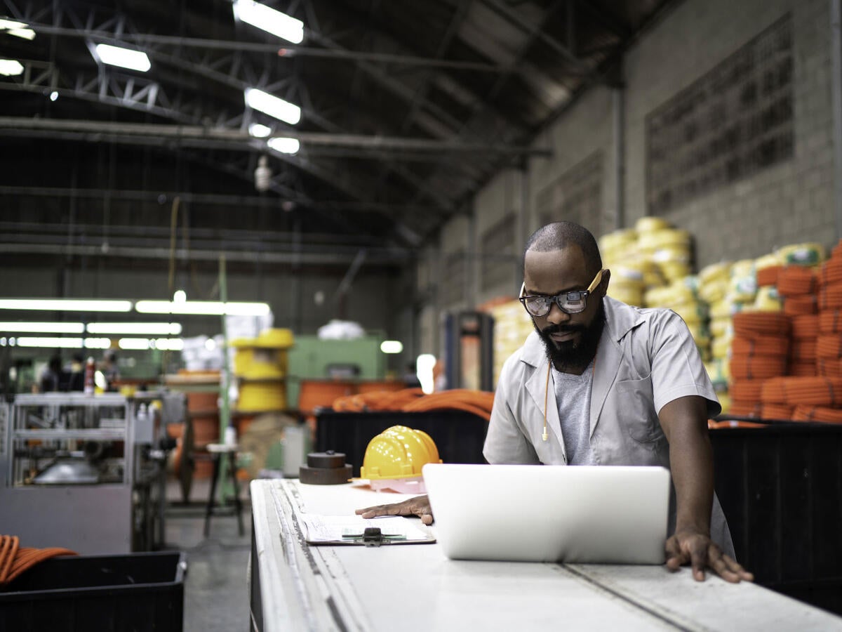 Person working on a laptop in a warehouse