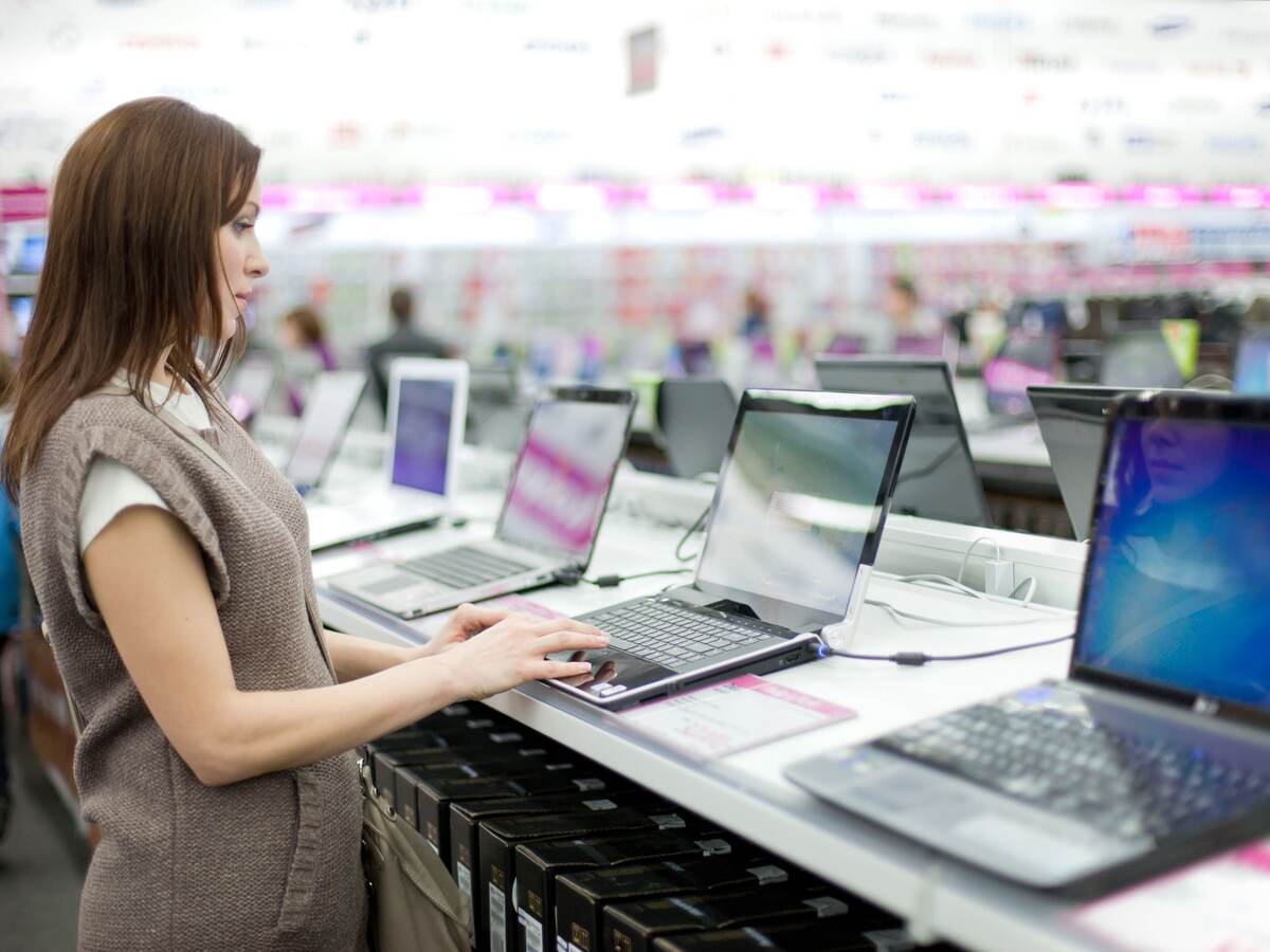 Woman chooses the laptop.