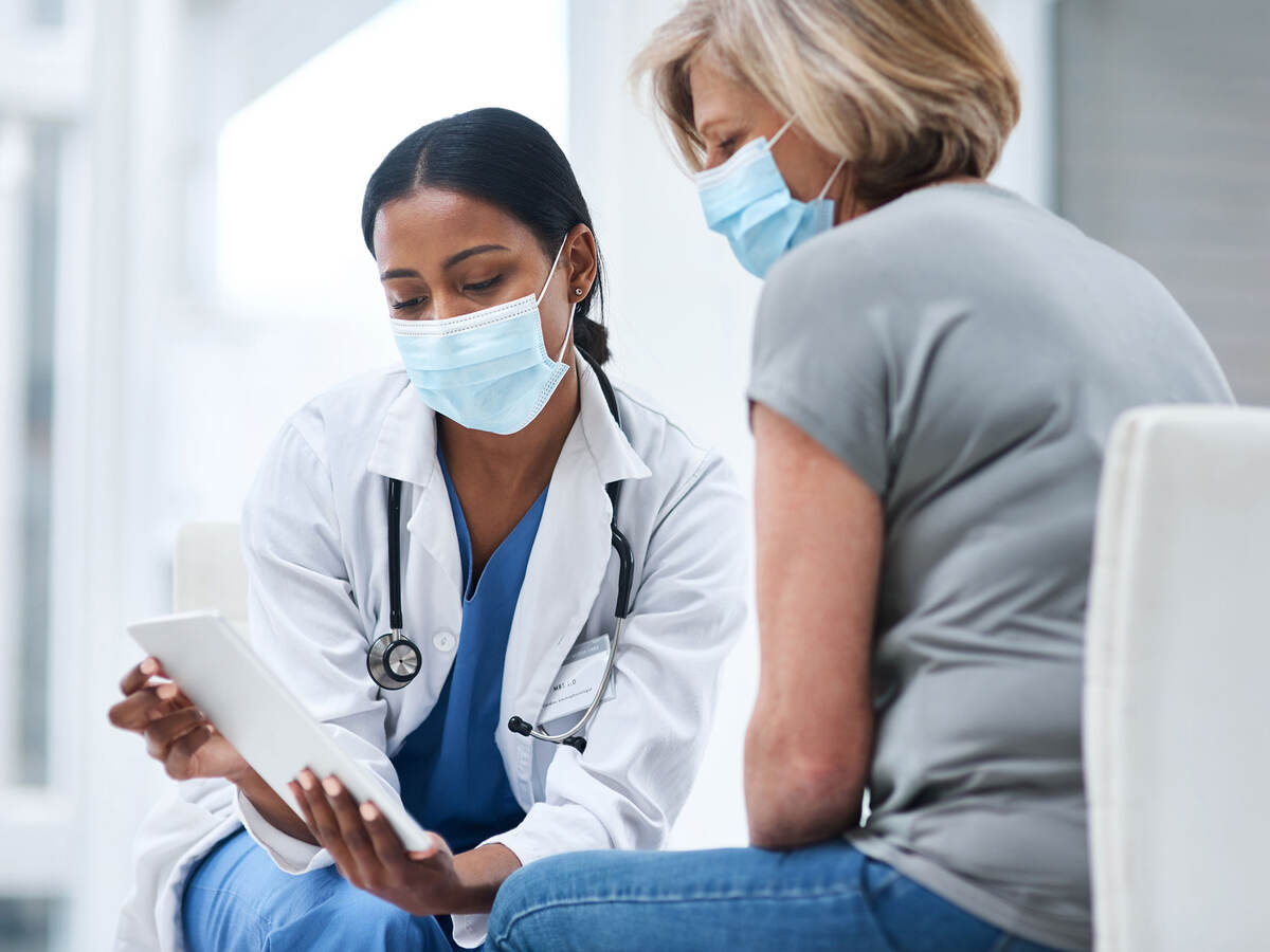 Doctor and patient looking at a tablet in an office. 