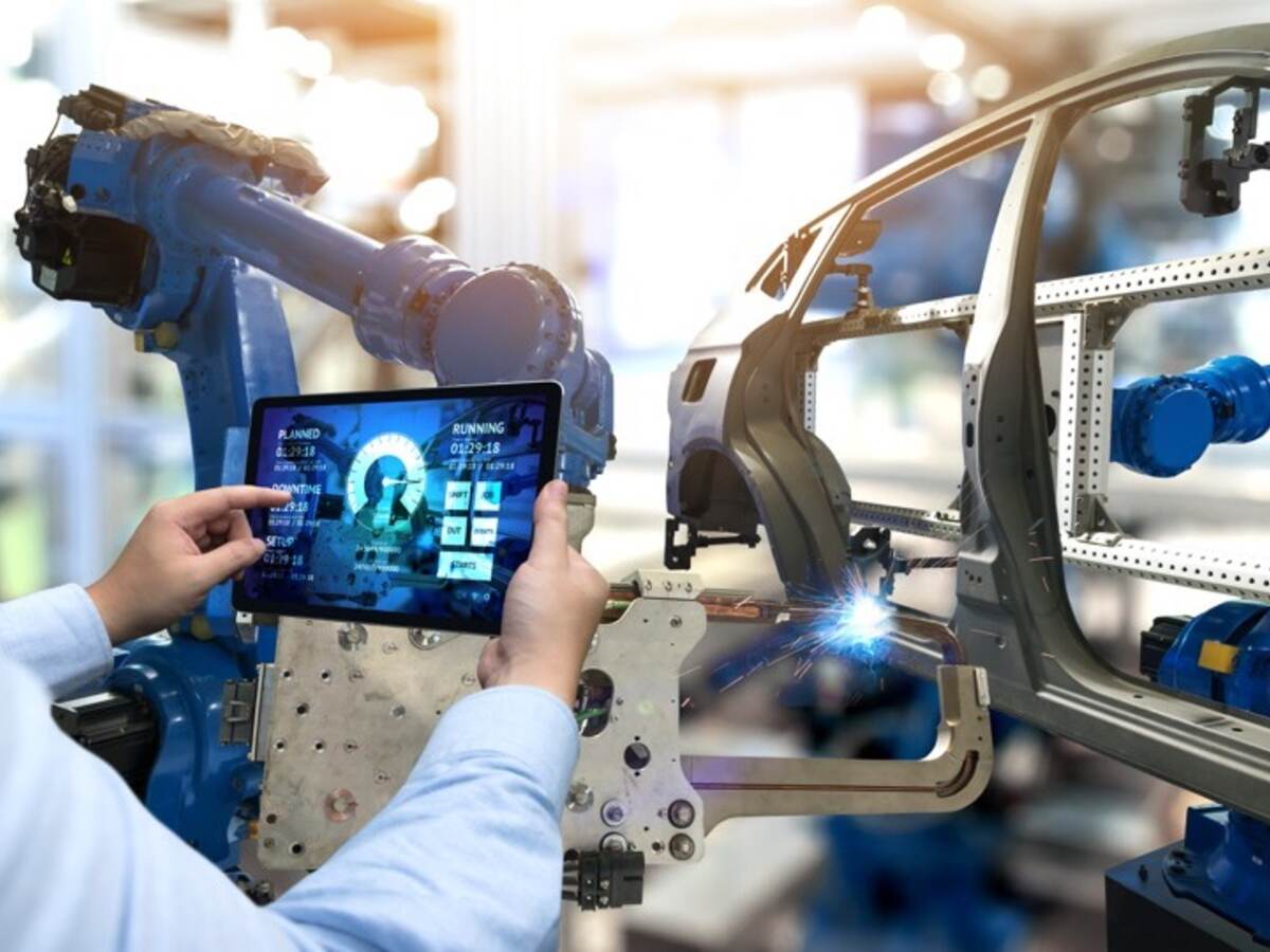 man holding tablet by car chasis