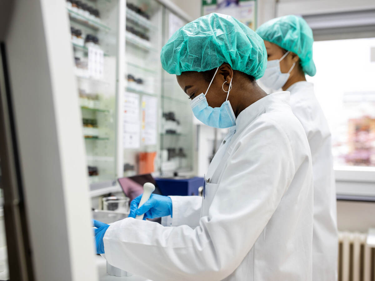 Two chemists working while wearing PPE