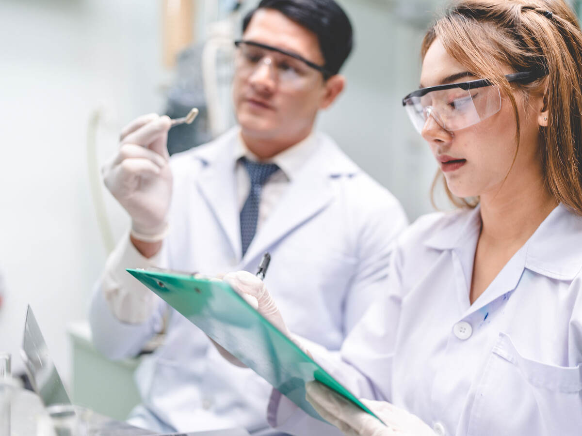 Two pharmaceutical chemists review a capsule