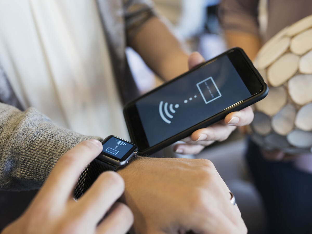 A person pairing up a cellphone and smart watch