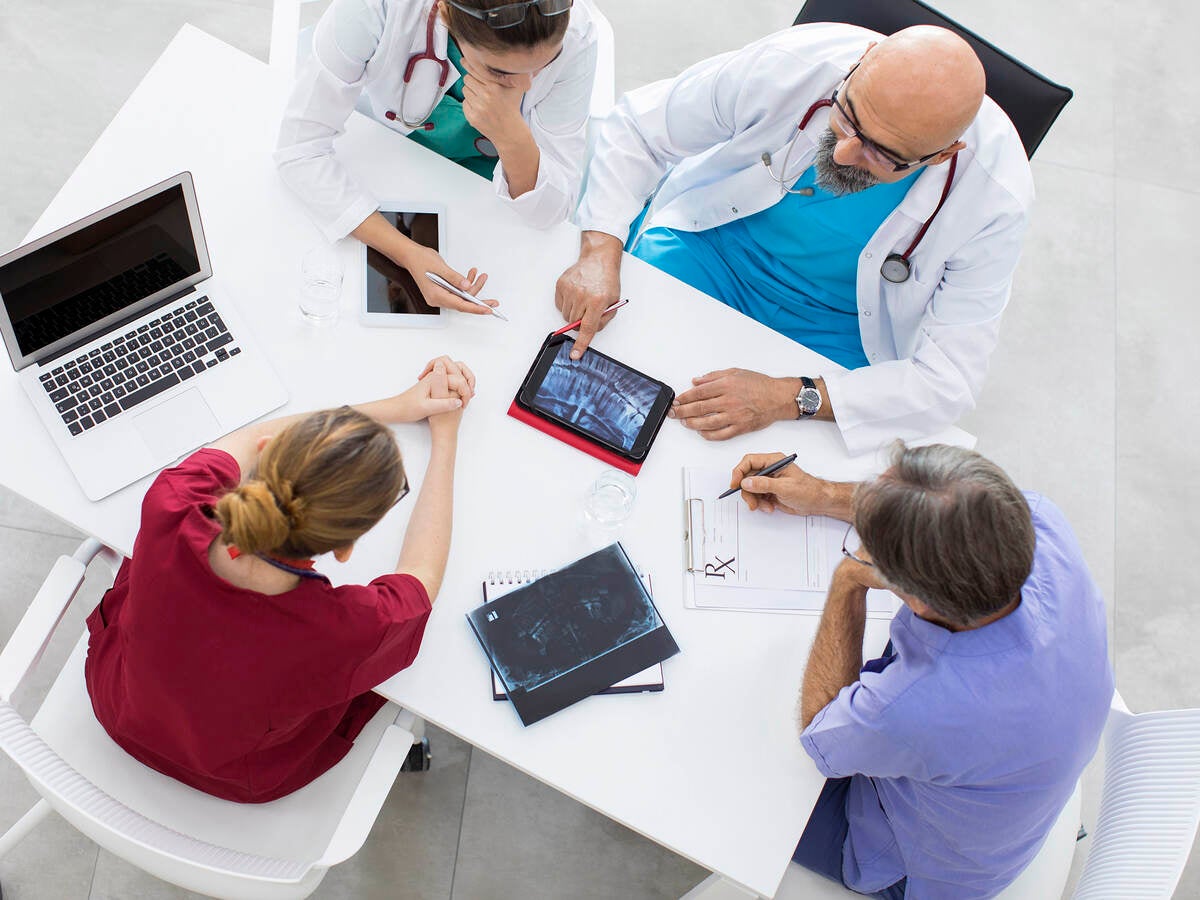 Medical team sitting and discussing at table.