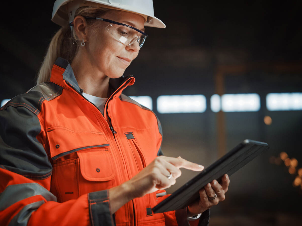 Engineer in PPE working on a tablet