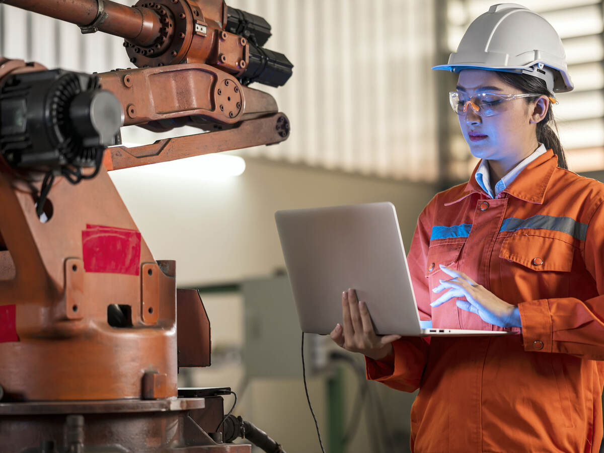 Person in factory working on a laptop