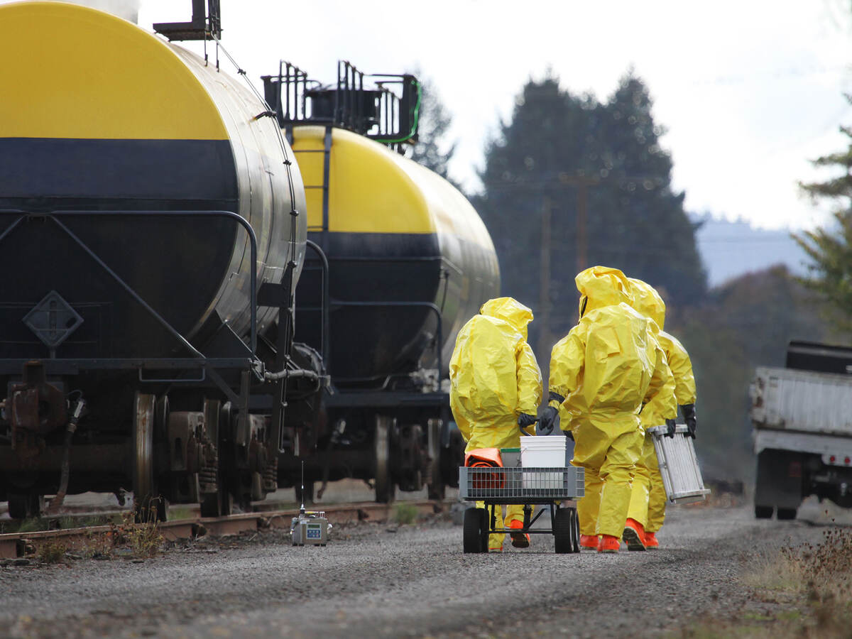 HAZMAT team members investigate chemical disaster near railroad tracks
