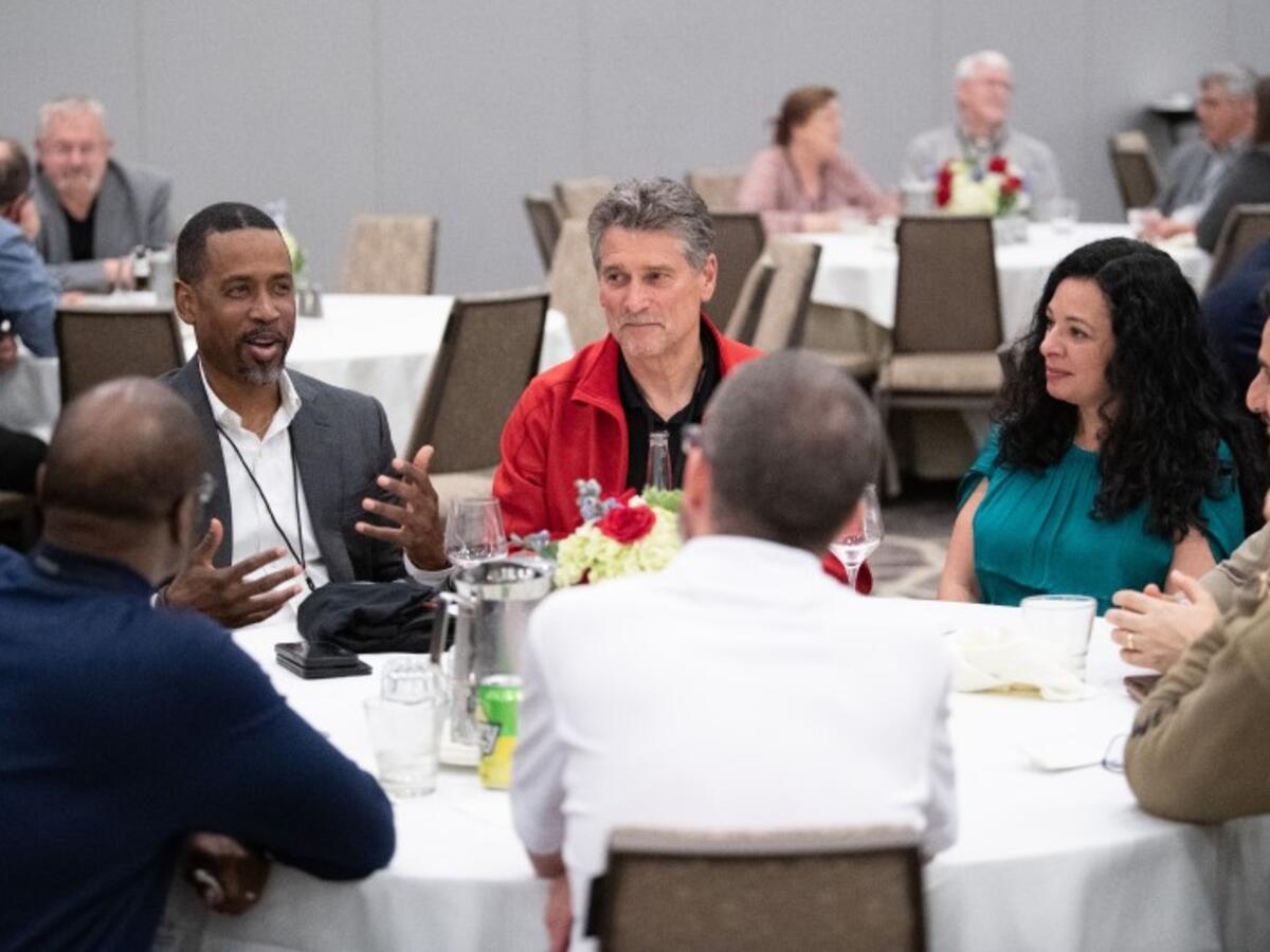 Karriem Shakoor in conversation with others at table.