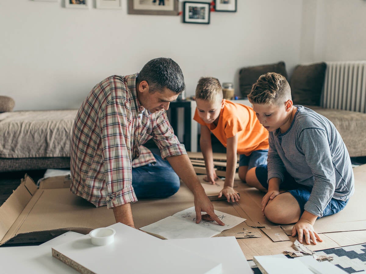 Father is assembling furniture with his kids.