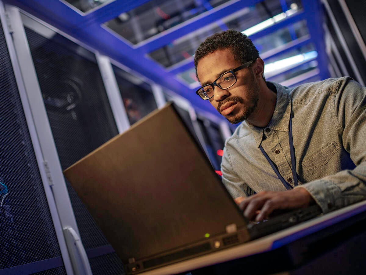 IT engineer using a computer in the server room