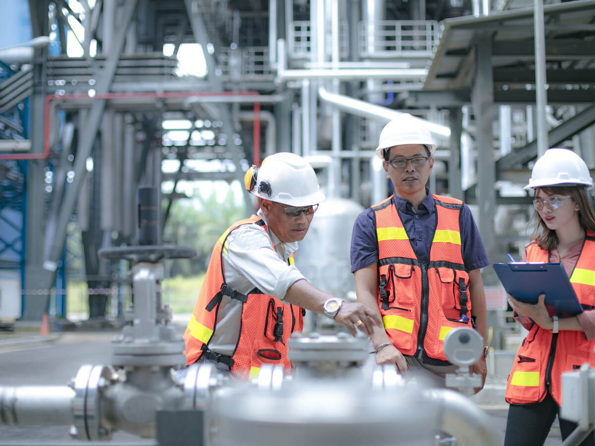 Pipeline oil engineers having a discussion in a factory