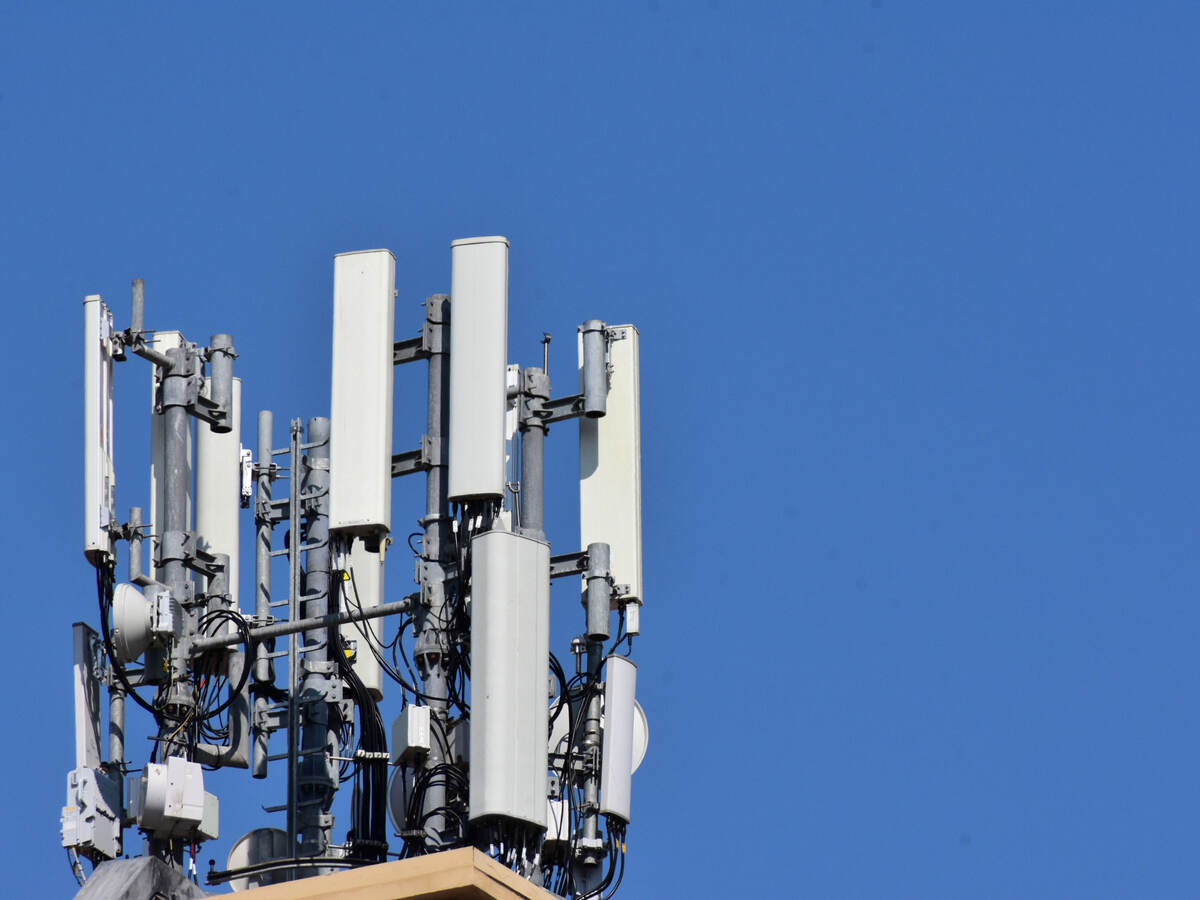 Antennas on a roof with blue sky behind it. 