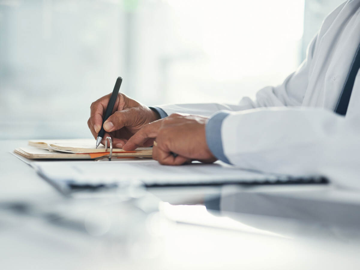 Close up of a doctor writing notes on paper 