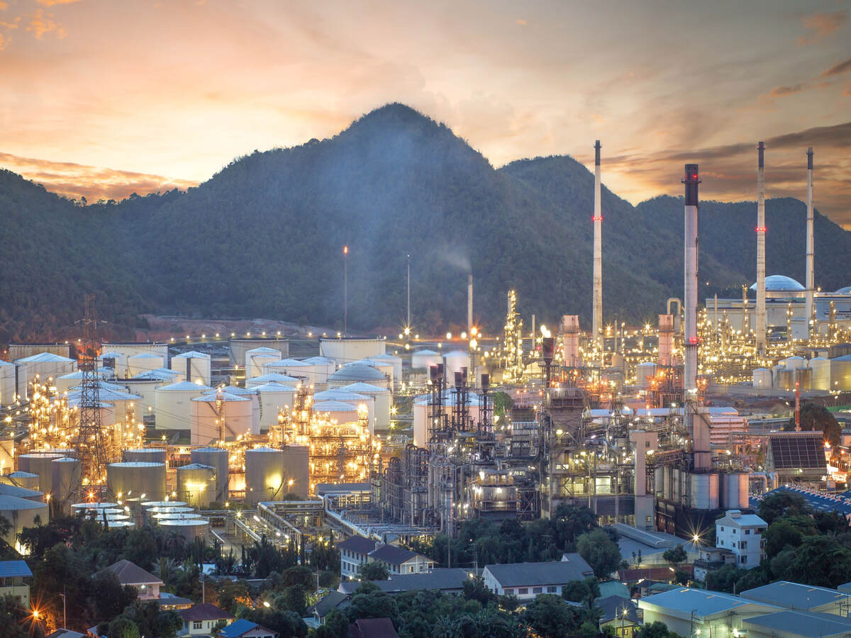 Oil refinery, aerial petrochemical storage tanks with refining industrial floor, oil refinery at night.