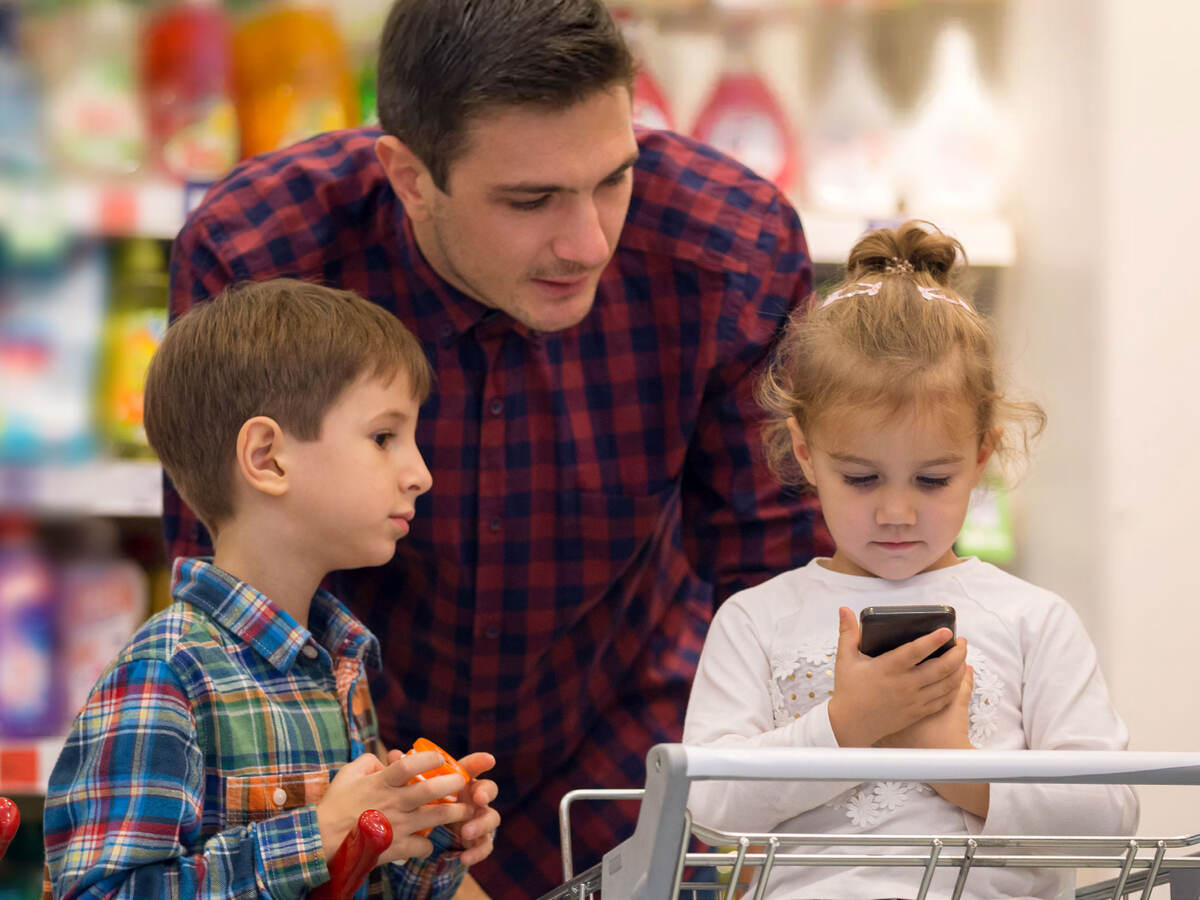 Family at a store looking at a smartphone while shopping