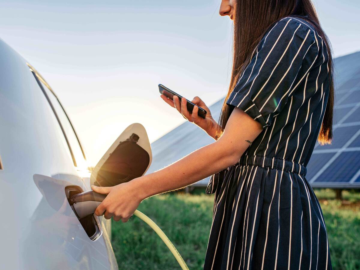 Woman charging an electric vehicle.