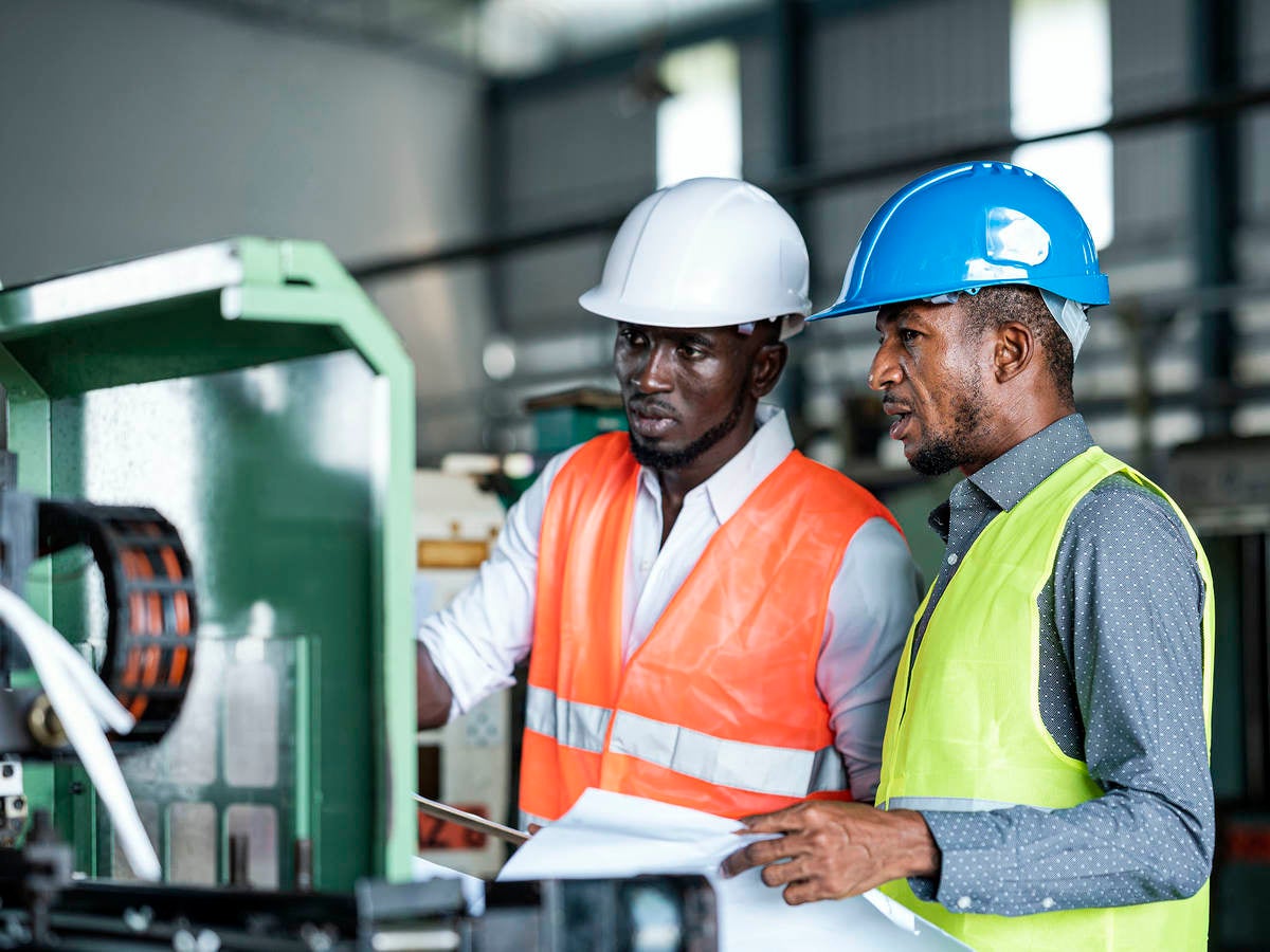 African Businessmen and Production Manager during meeting with production scheduling plan in a factory.