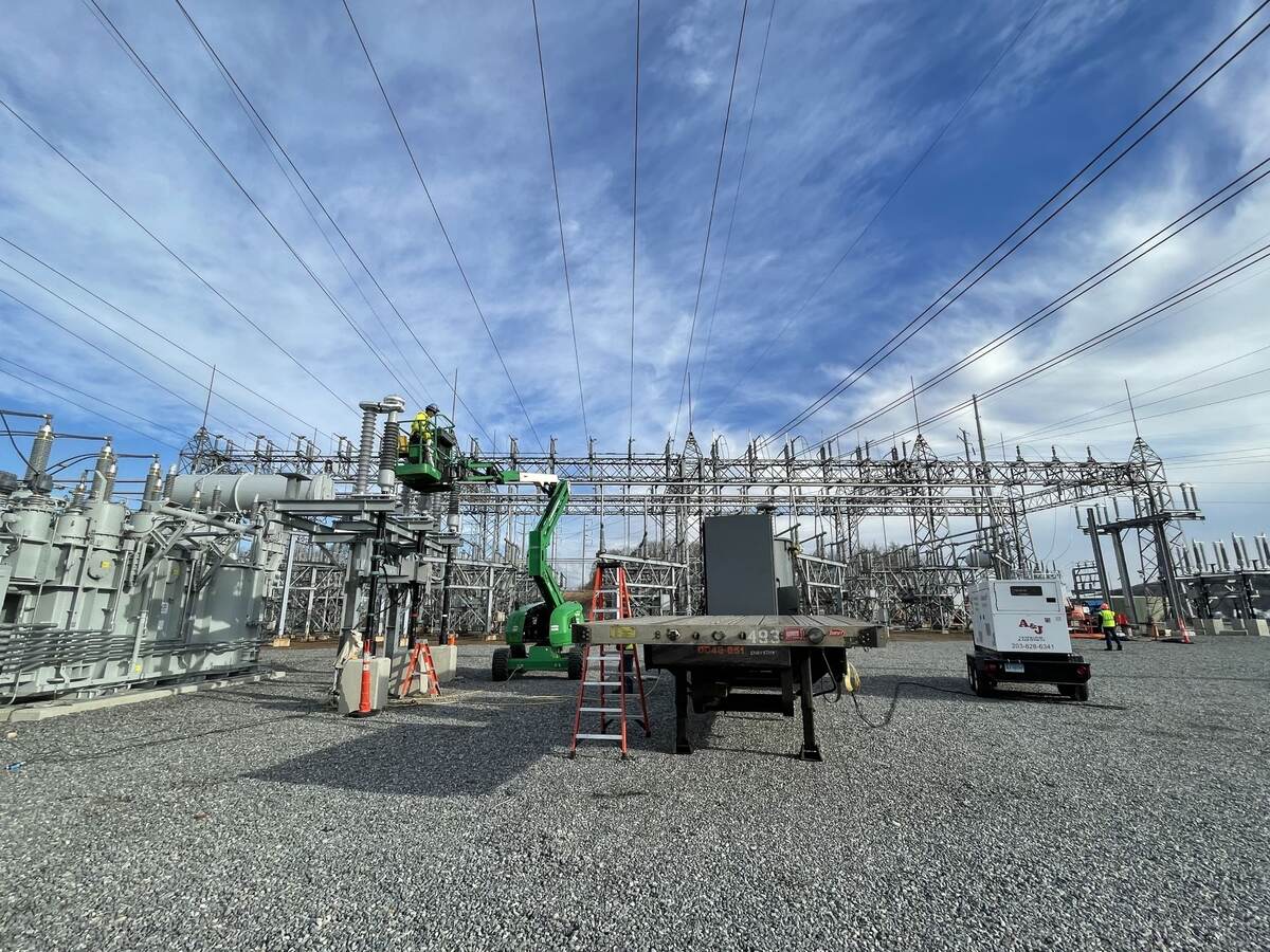 Worker inspecting high voltage cables.