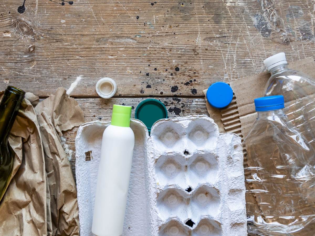 Various types of garbage for recycling on a wooden background.