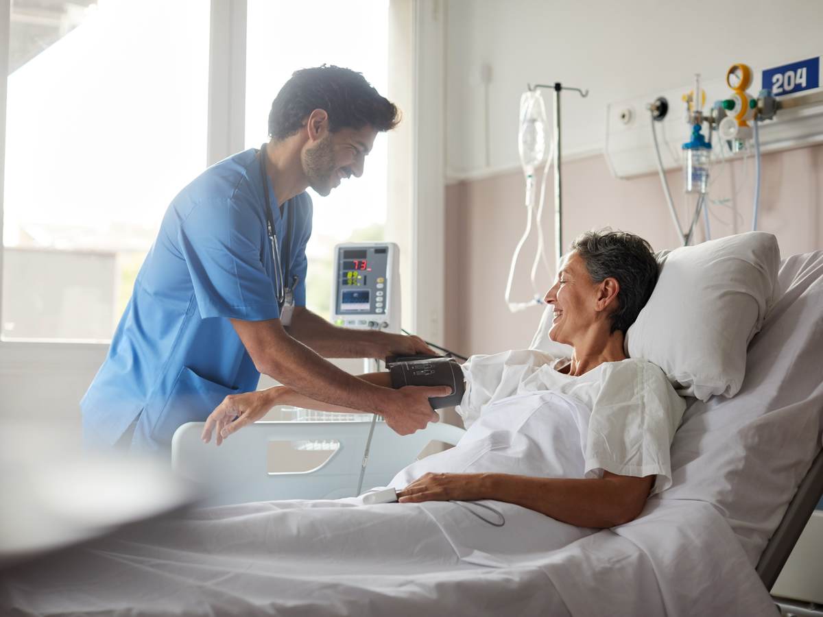 Nurse taking pulse of patient.