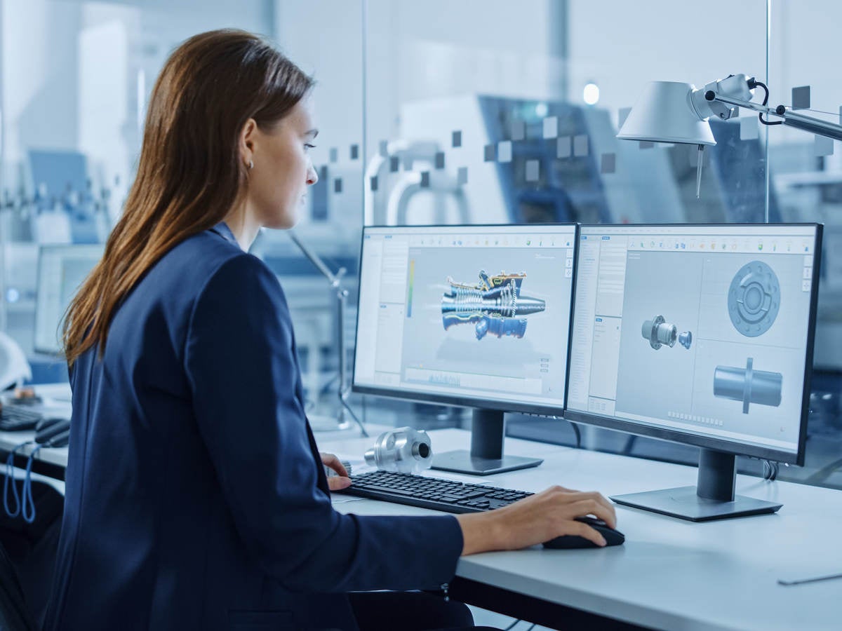 Portrait of Young and Confident Industrial Engineer Working on Computer, on Screen CAD Software Showing New Generation Electric Engine.