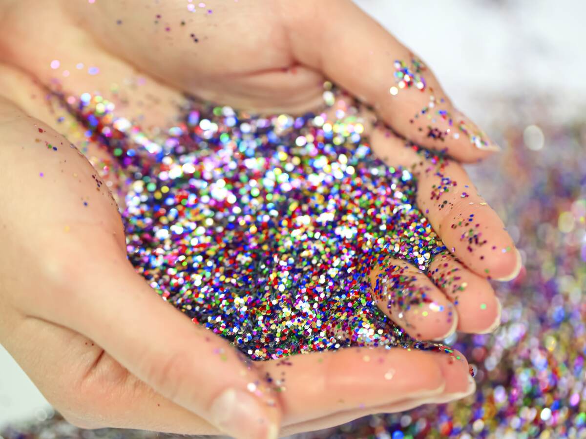 Hands holding loose glitter.