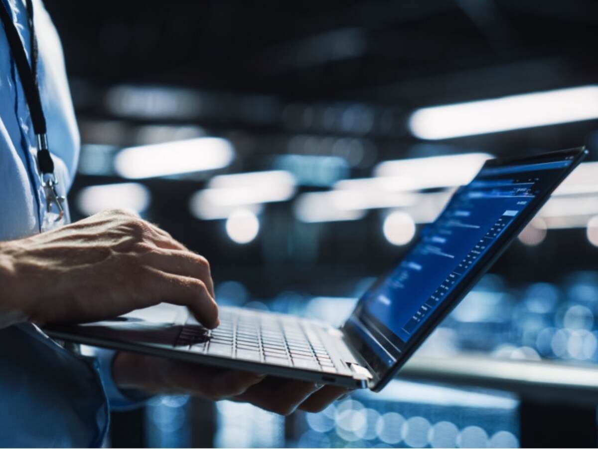 laptop being held by a man in a blue shirt