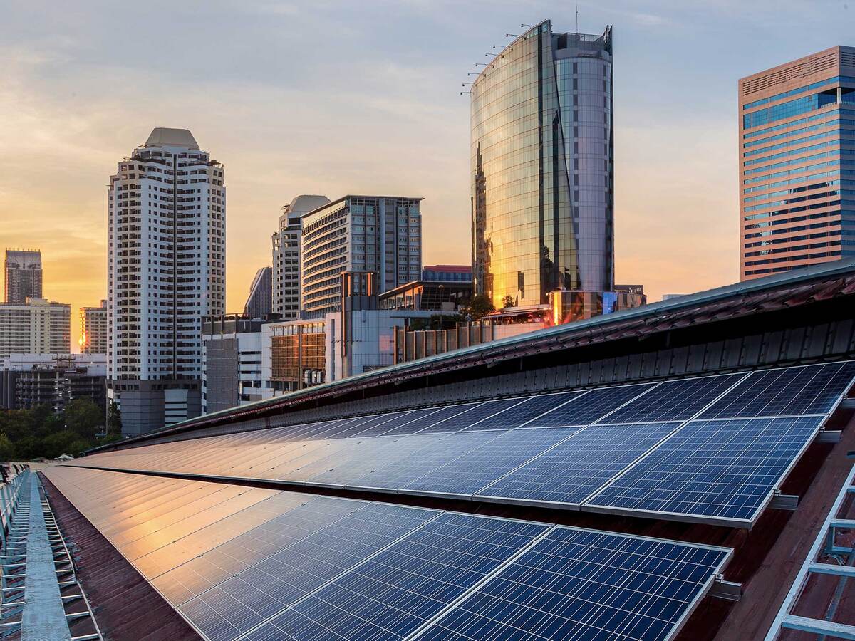 Solar panels on a skyscraper roof in the city during a sunrise. 