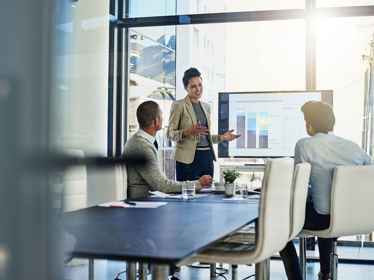 Three business colleagues reviewing metrics in a meeting