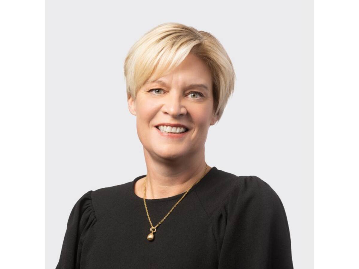 Headshot of Mette Pedersen in black sweater against gray background. 