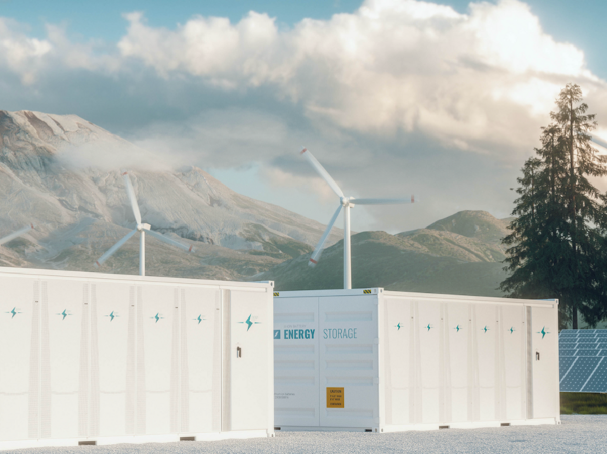 Energy storage, wind turbines and solar panels with mountains in the background