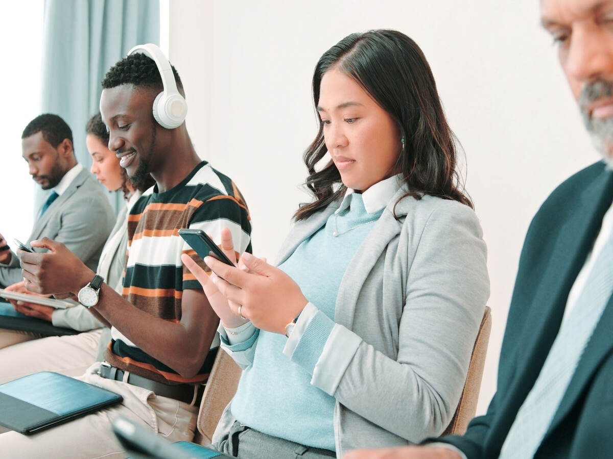 People in a waiting room and using mobile devices