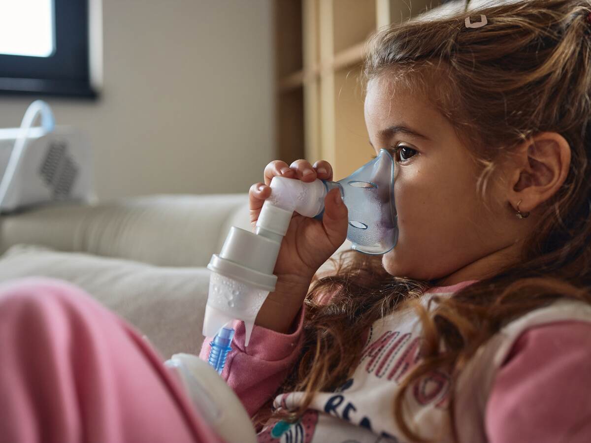 Young child using nebulizer during inhaling therapy