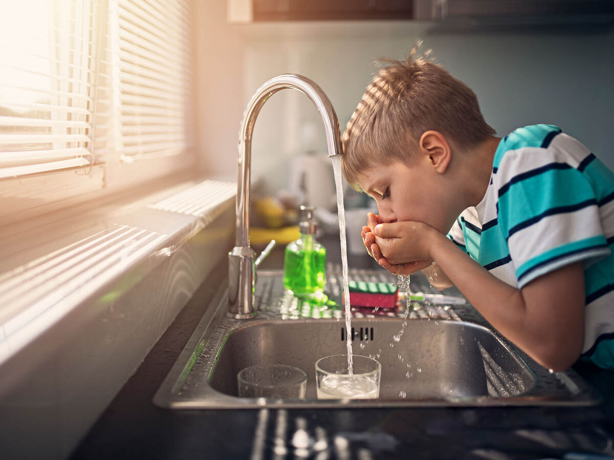 young person drinking tap water from the faucet