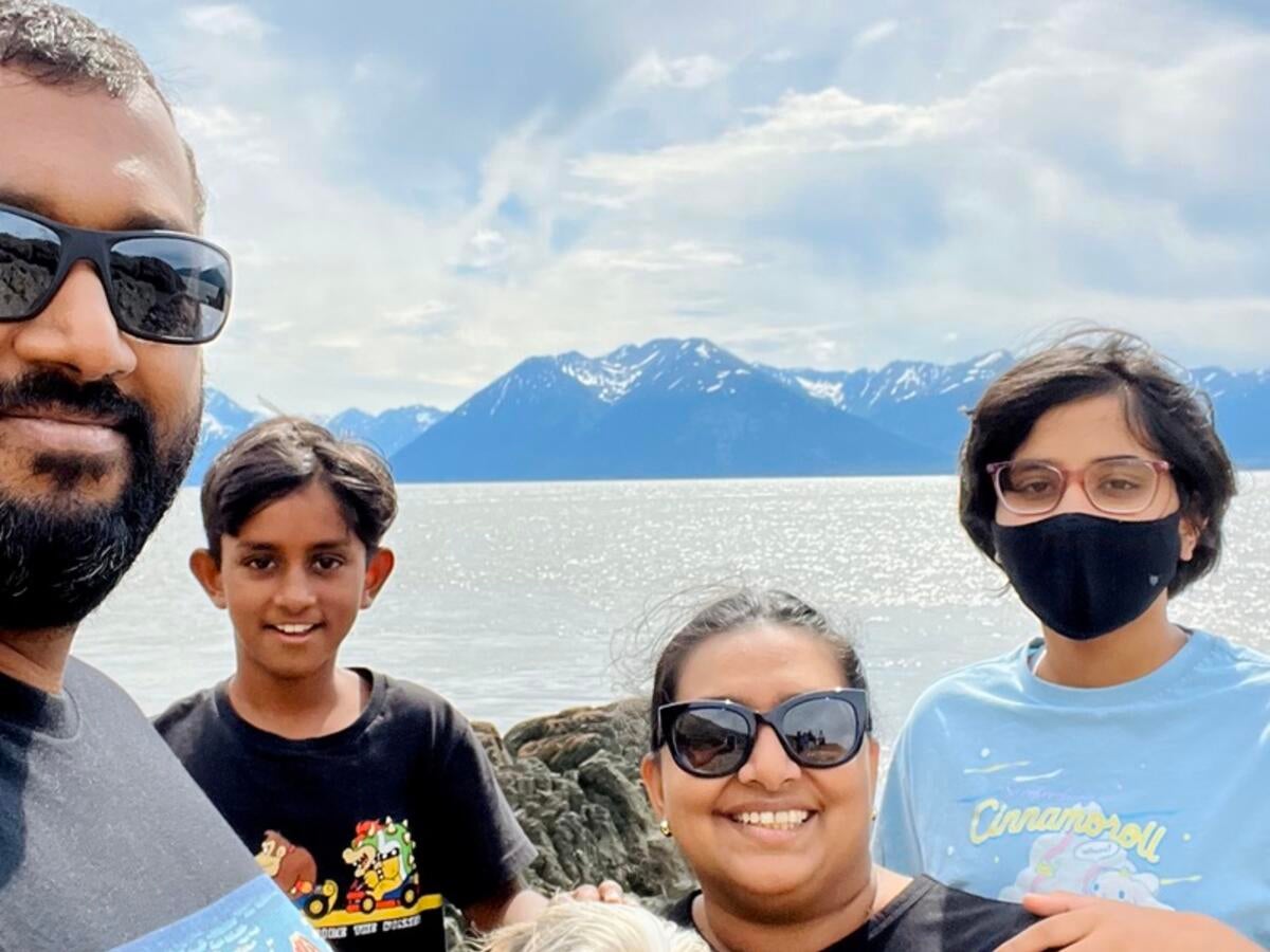Rohit Jacob and his family in front of lake and mountain view.
