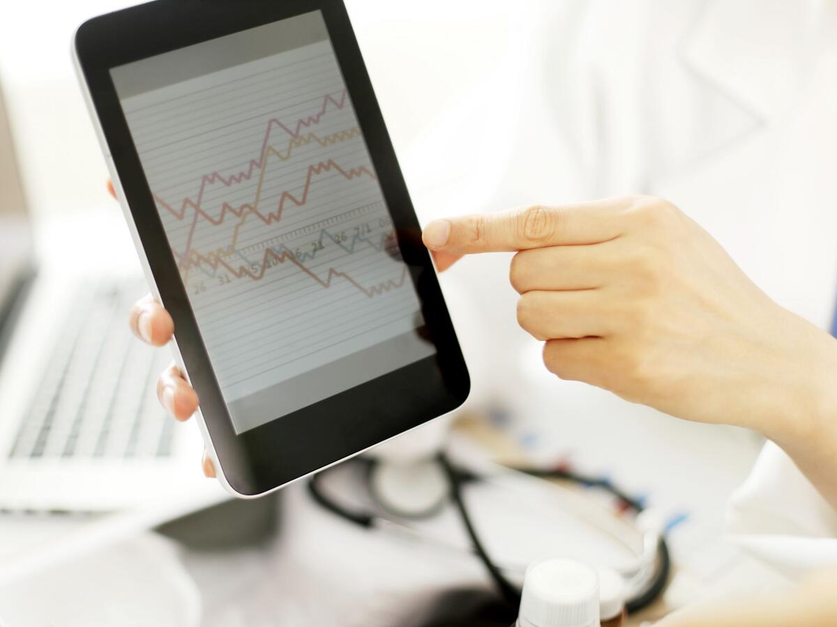 Doctor hands hold and show digital tablet pc to patient.
