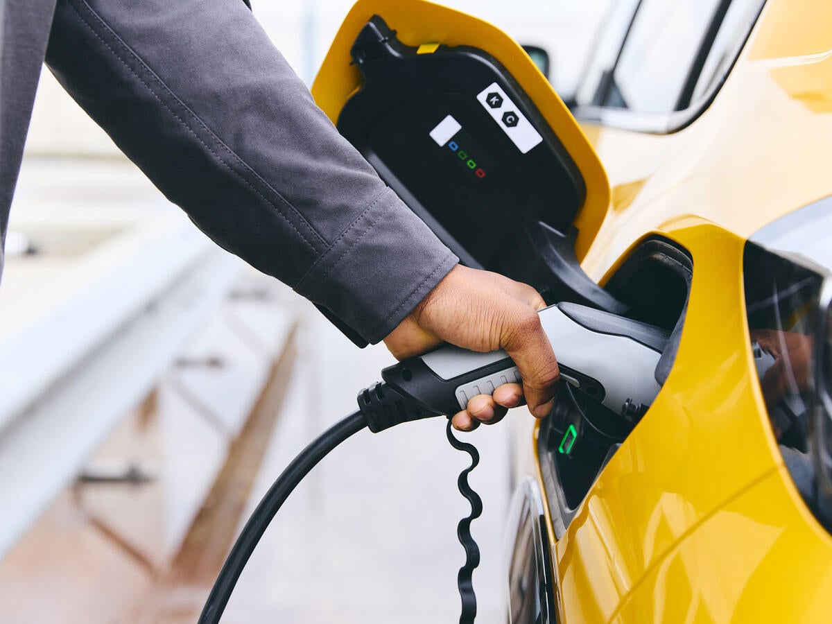 Person plugging their electric vehicle into a charger