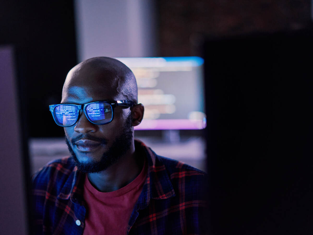 It specialist in glasses reviewing work on a monitor