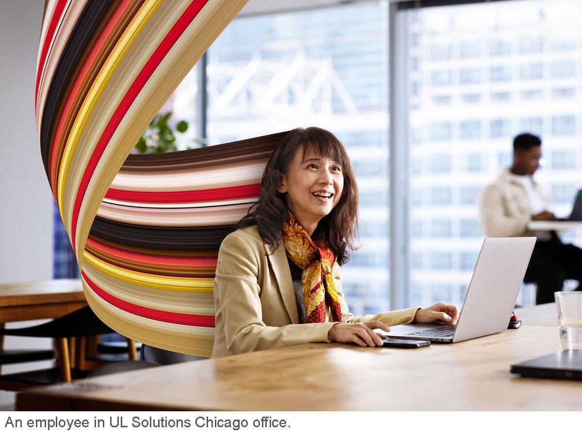An employee working at a desk and smiling