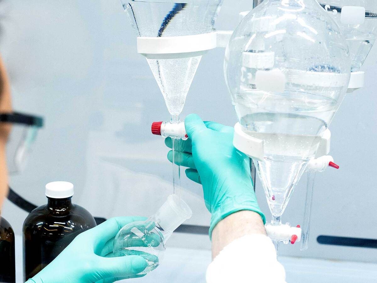 Lab scientist titrating a solution into a beaker