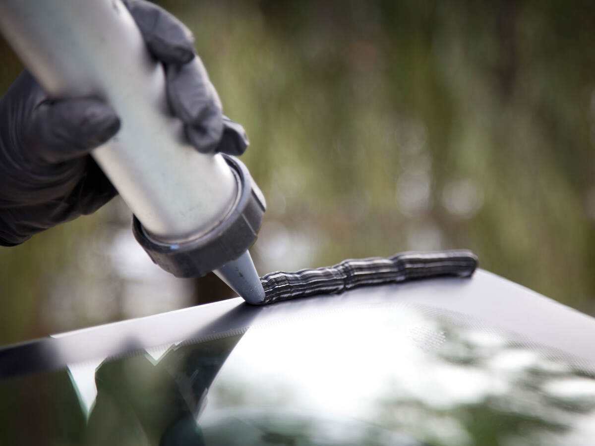 a person applying sealant to a windshield