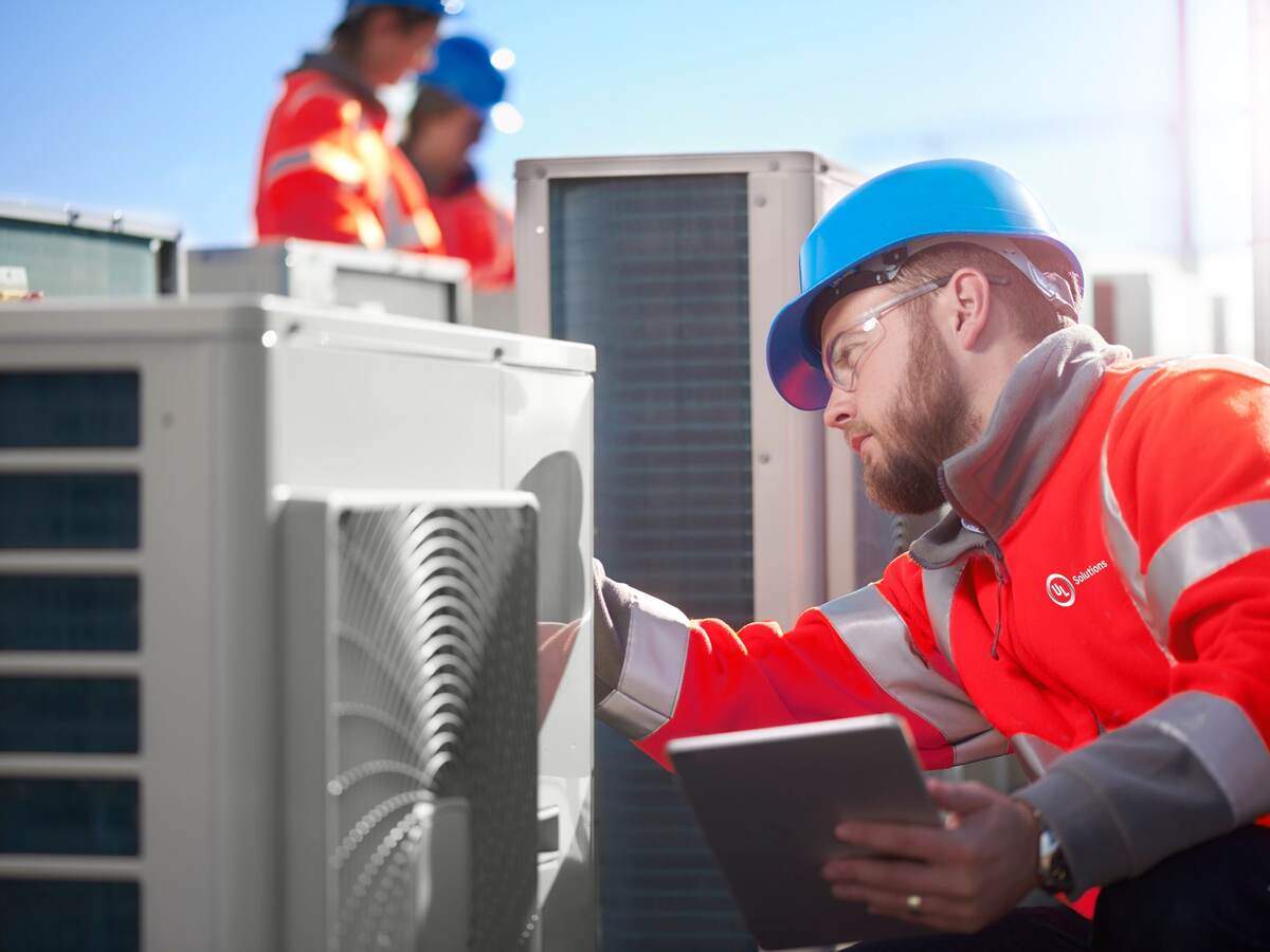 Man inspecting an outdoor unit of air conditioner