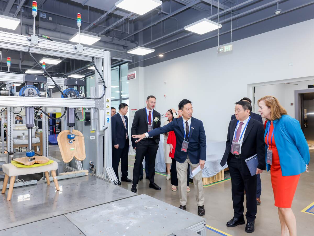 Jennifer Scanlon, president and CEO of UL Solutions (at right) and Weifang Zhou, EVP and president of Testing, Inspection and Certification (second from right) and other executives listen as Roy Poon, Asia Pacific regional operations director for Retail and Consumer Products, describes equipment that tests the performance of furniture during a March 25 tour of the company’s Retail and Consumer Products Laboratory in Ningbo, China.