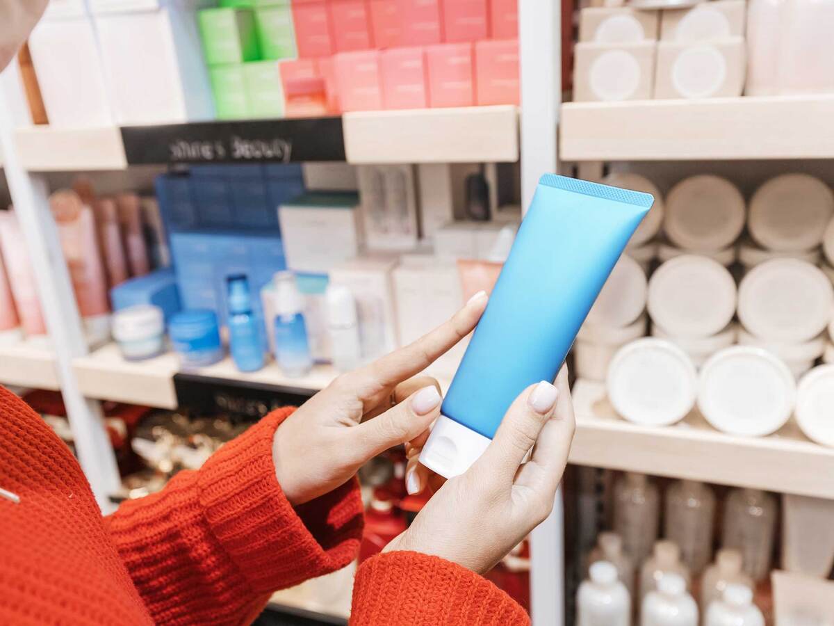 Person holding a bottle of cream at the store