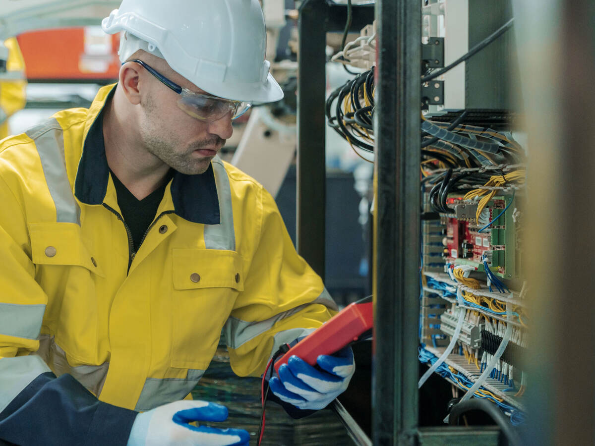 A worker using a voltage meter