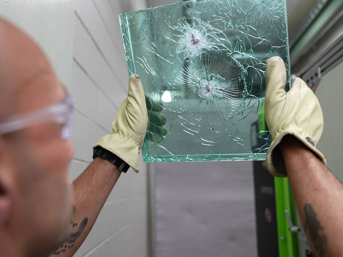 a person holding up bullet-proof glass