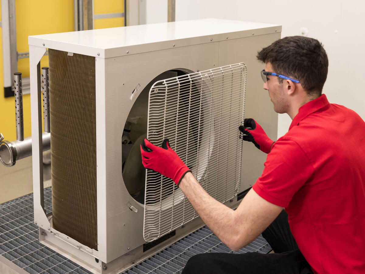 A person removing the grill of an HVAC unit