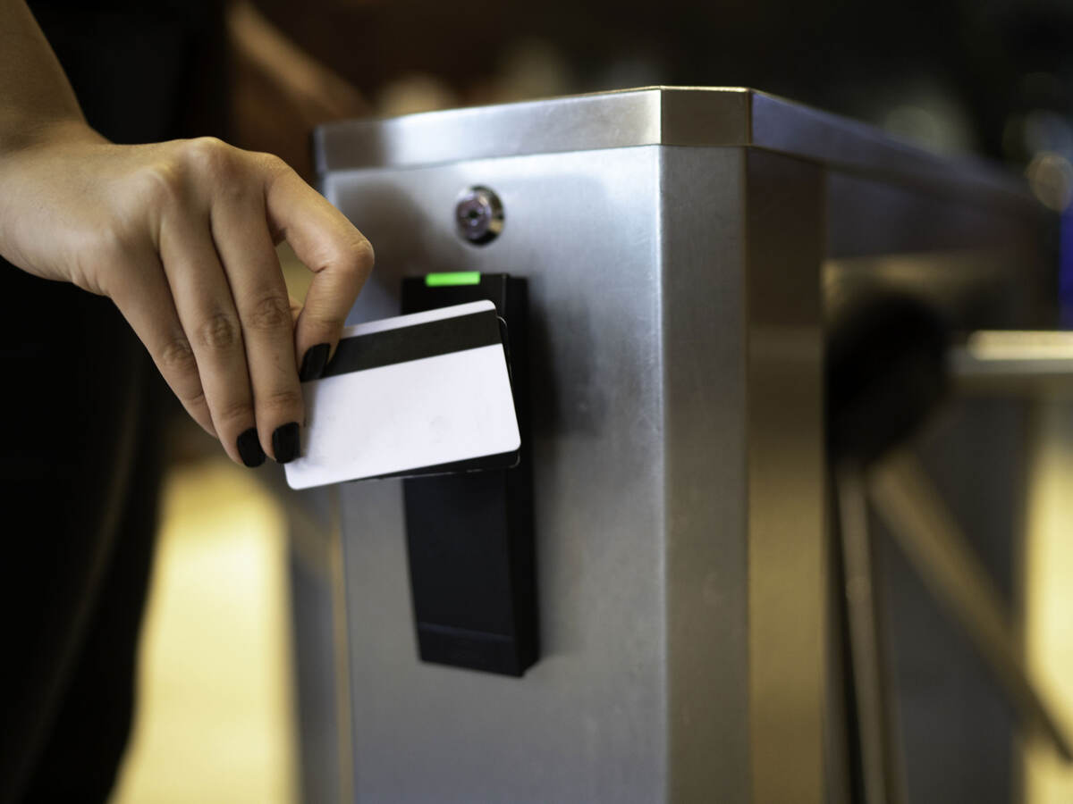 A person using a card reader at a turnstile